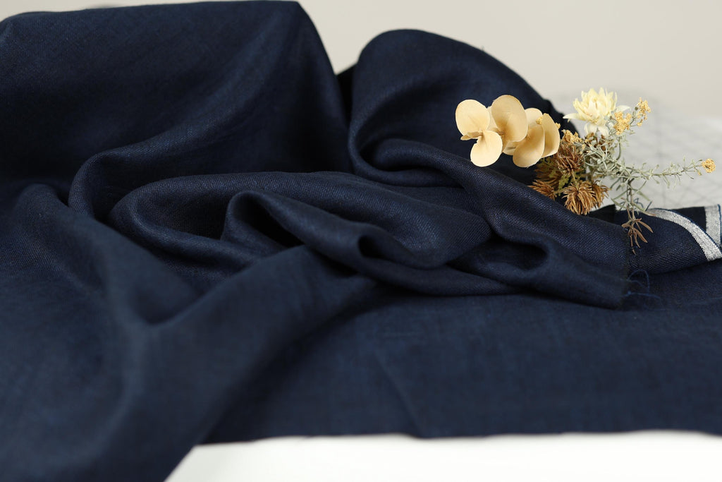 a close-up view of a dark blue fabric with a small bouquet of yellow flowers resting on top of it.