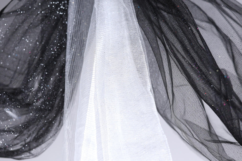 a close-up view of a black and white fabric with a shiny, glittery texture.