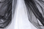 a close-up view of a black and white fabric with a shiny, glittery texture.