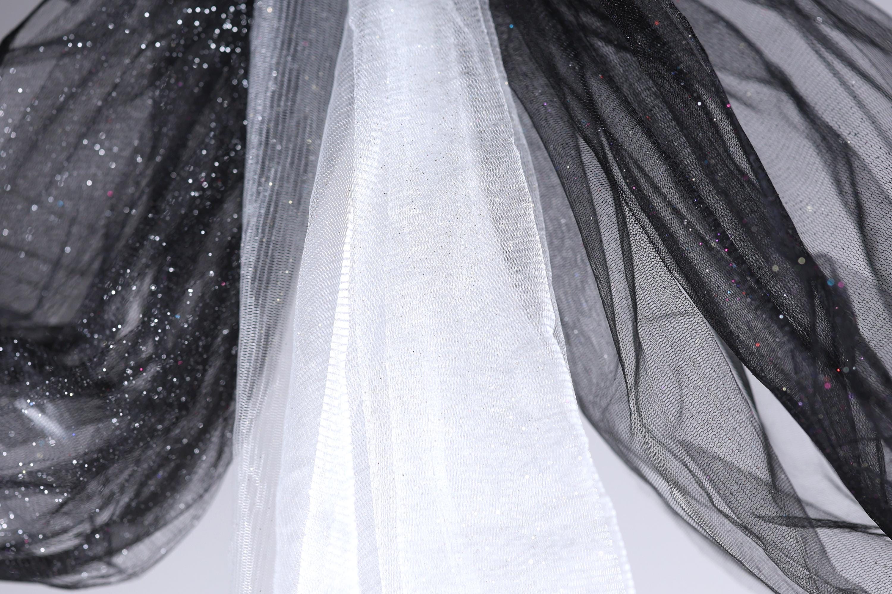 a close-up view of a black and white fabric with a shiny, glittery texture.