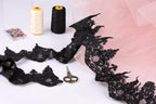 sewing supplies, including spools of thread, scissors, and a piece of lace, arranged on a white background.
