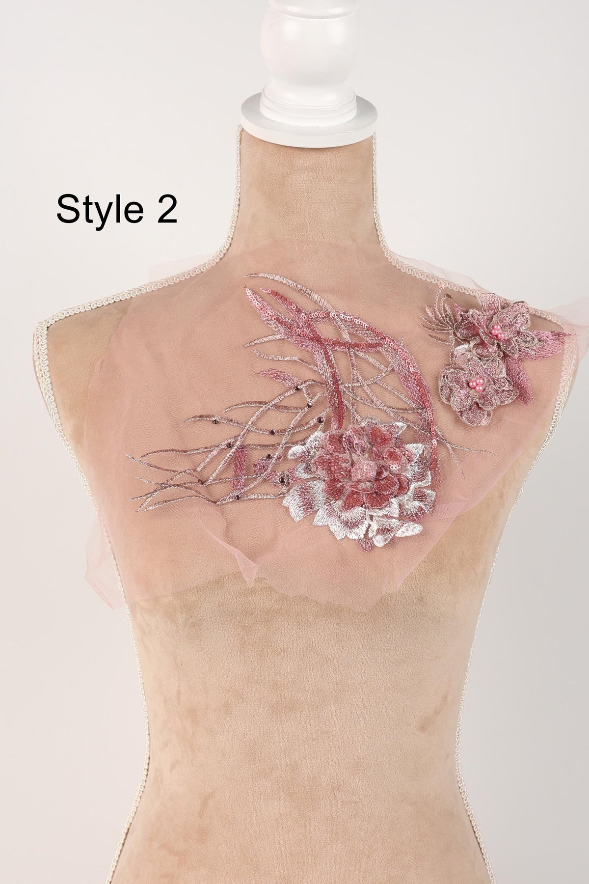 A mannequin with a pink floral design on its back, featuring a large pink flower and smaller pink flowers.