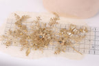 a close-up view of a delicate gold and white floral embroidery piece, with a ruler placed next to it.