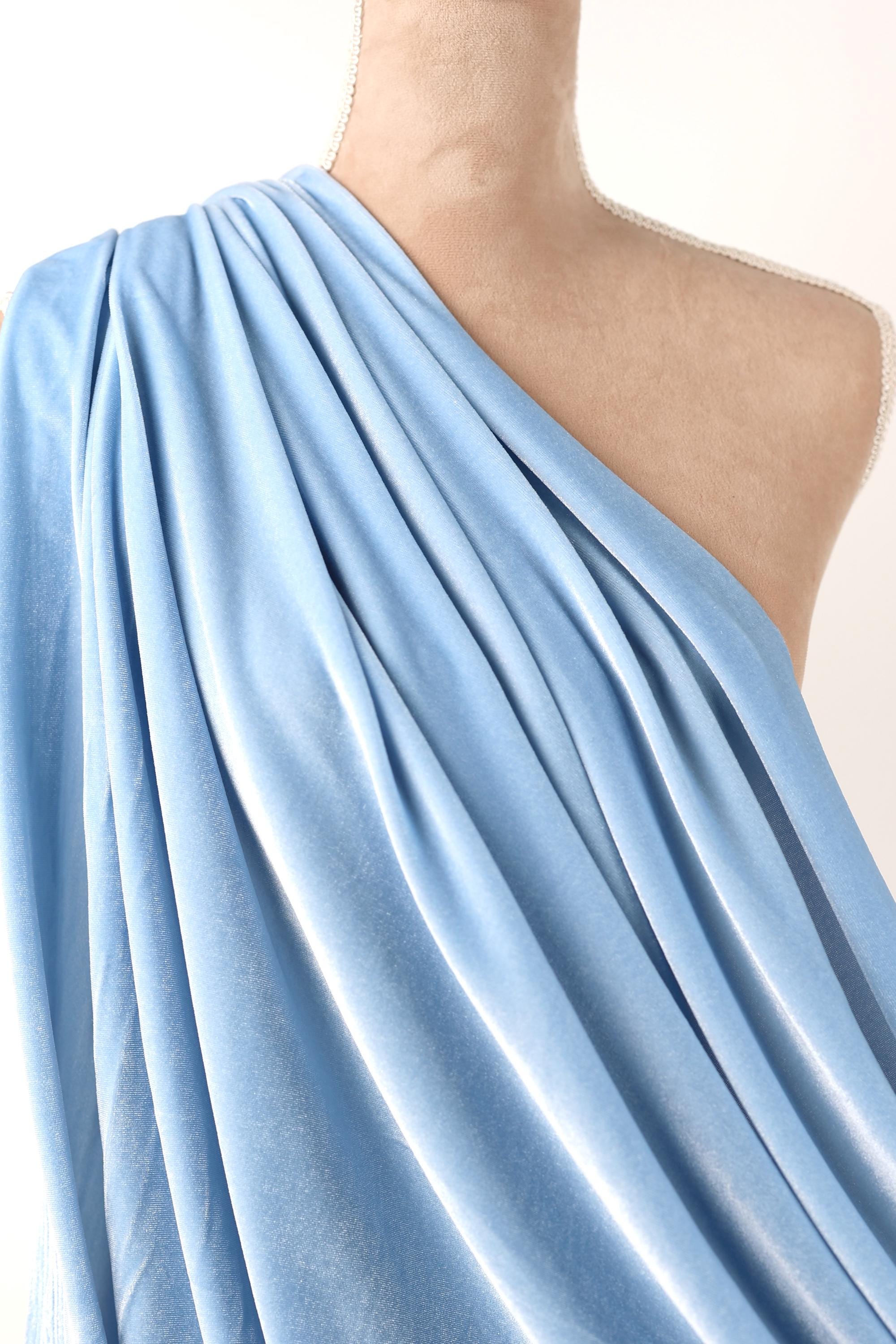A mannequin wearing a blue draped dress with a flowing, draped appearance.