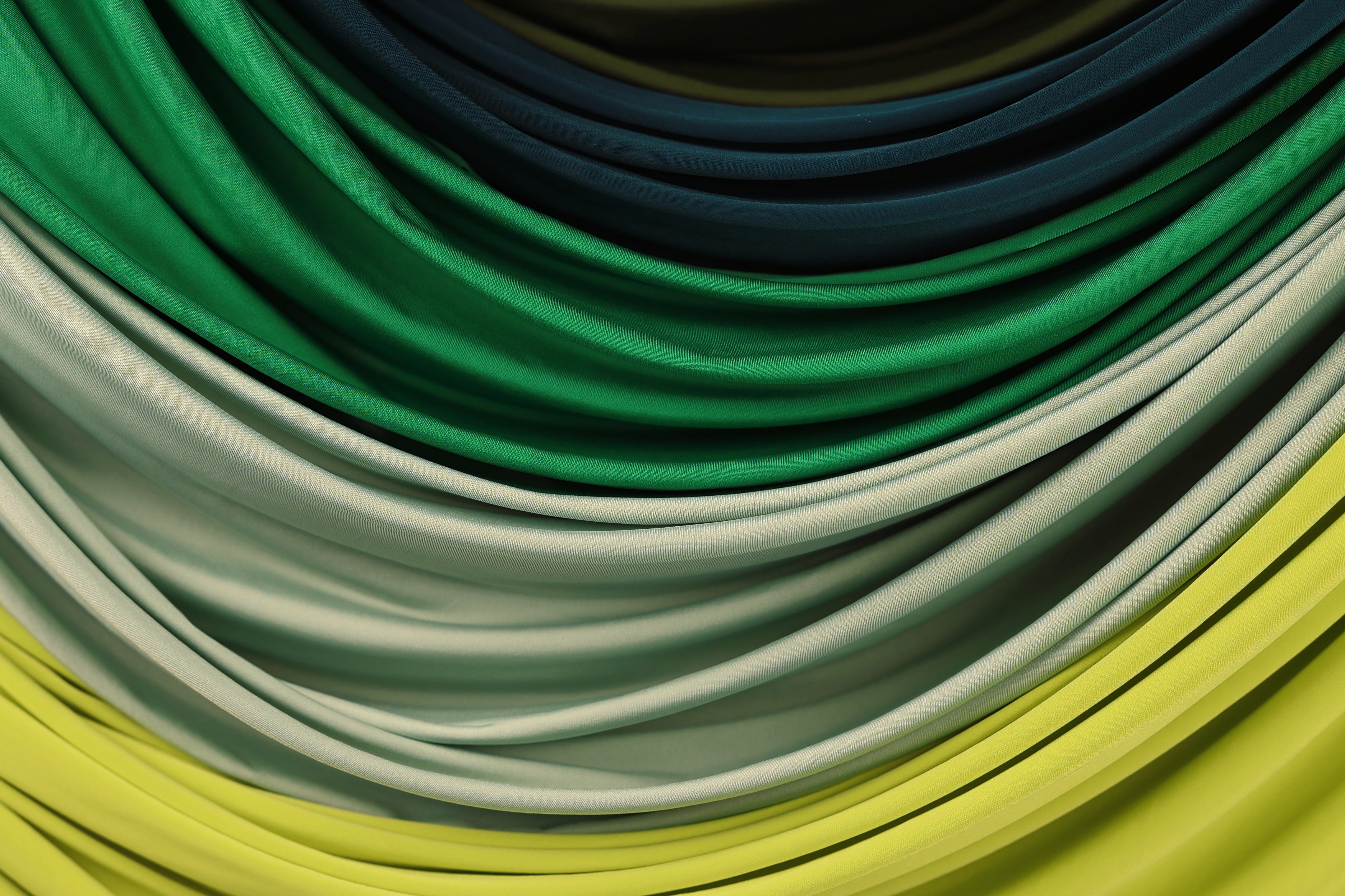 a close-up view of a collection of colorful fabric swatches, including shades of green, blue, and yellow.