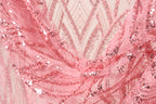 A close-up view of a pink sequin fabric, with intricate patterns and designs visible.