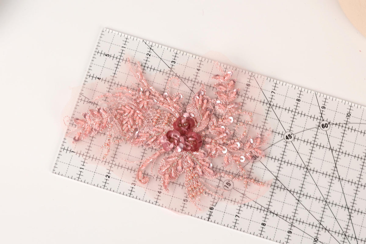a clear ruler with a pink floral design placed on top of it.