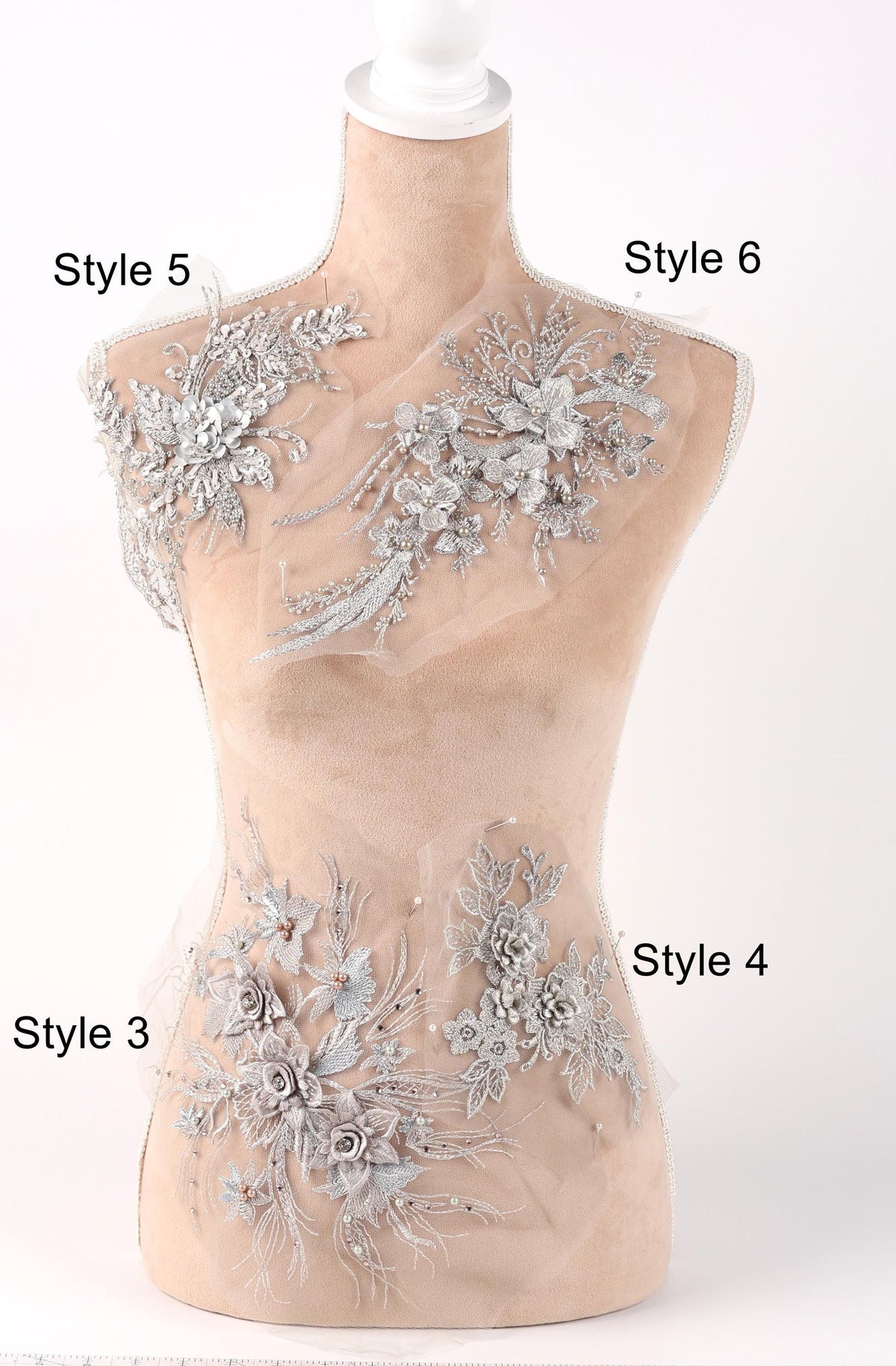 A mannequin with various decorative floral and lace embellishments on its bust and hips, labeled with different styles.