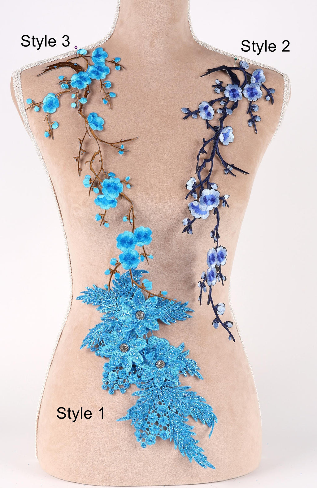 A mannequin with two distinct styles of blue floral embroidery on its bust. The left side features a floral design with blue flowers and branches, while the right side has a floral design with blue flowers and branches.