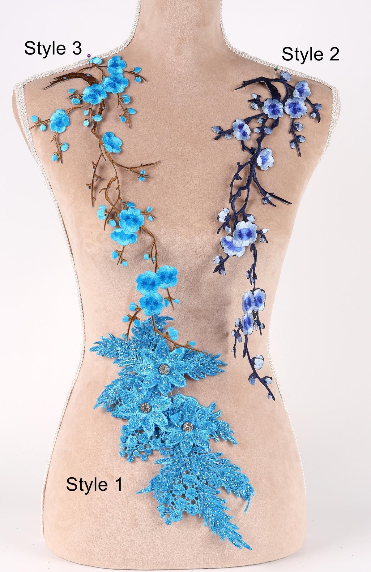 A mannequin with two distinct styles of blue floral embroidery on its bust. The left side features a floral design with blue flowers and branches, while the right side has a floral design with blue flowers and branches.