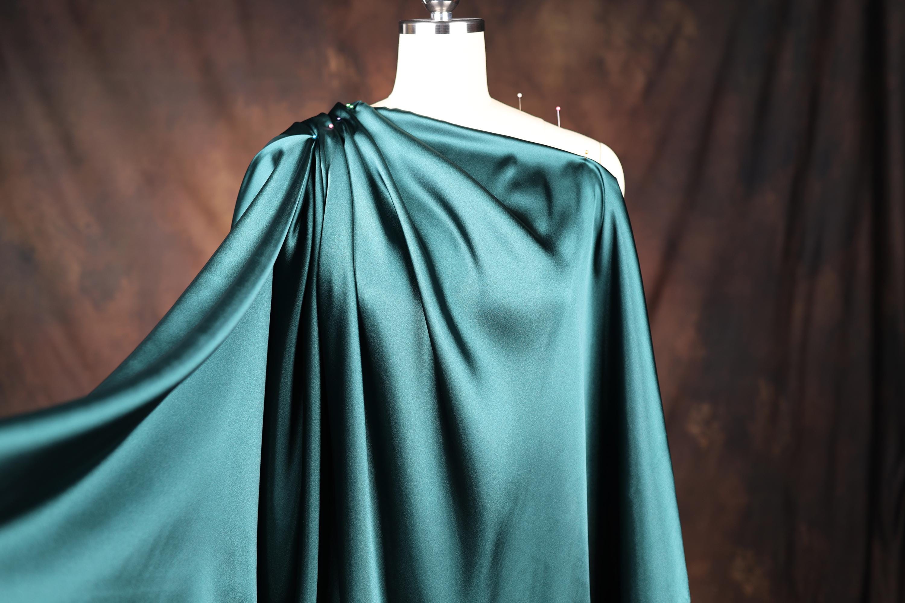 a dress on a mannequin with a green cape