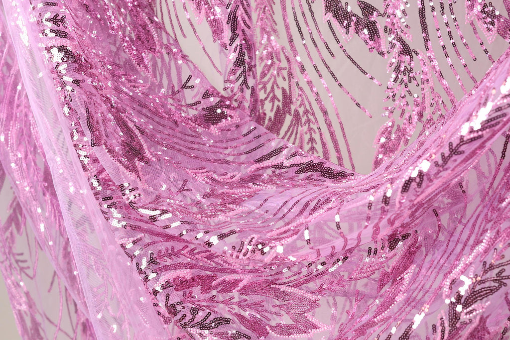 a close-up view of a fabric with a pink and purple sequined pattern. The fabric appears to be made of sheer material, with a delicate and intricate design.