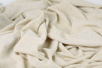 a close-up view of a crumpled, light-colored fabric, possibly a piece of linen or a similar material.