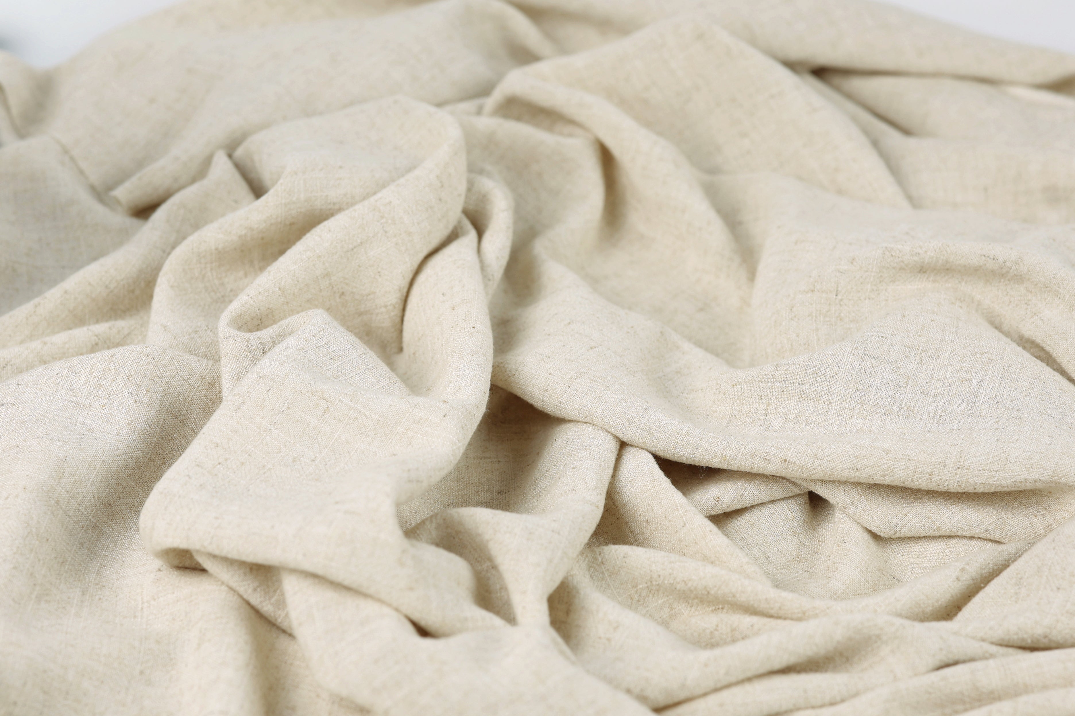 a close-up view of a crumpled, light-colored fabric, possibly a piece of linen or a similar material.