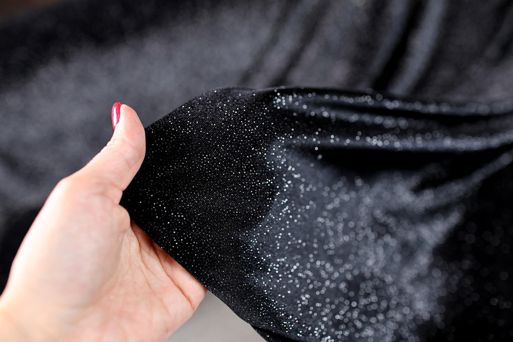 a woman's hand holding a black cloth