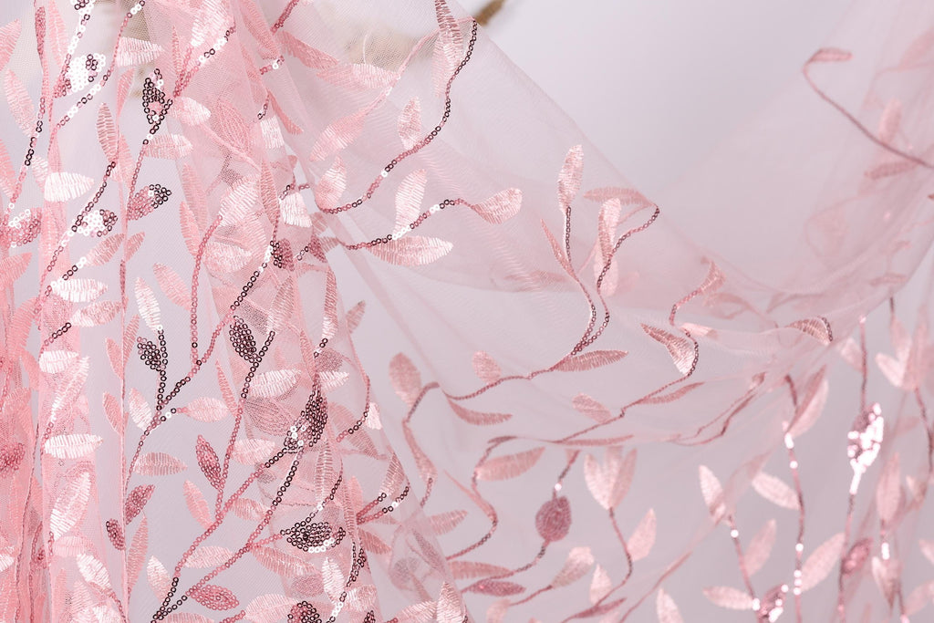 a close-up view of a delicate, pink, and white floral pattern on a fabric, with the leaves and branches intricately woven into the fabric.