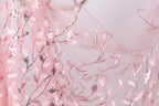 a close-up view of a delicate, pink, and white floral pattern on a fabric, with the leaves and branches intricately woven into the fabric.