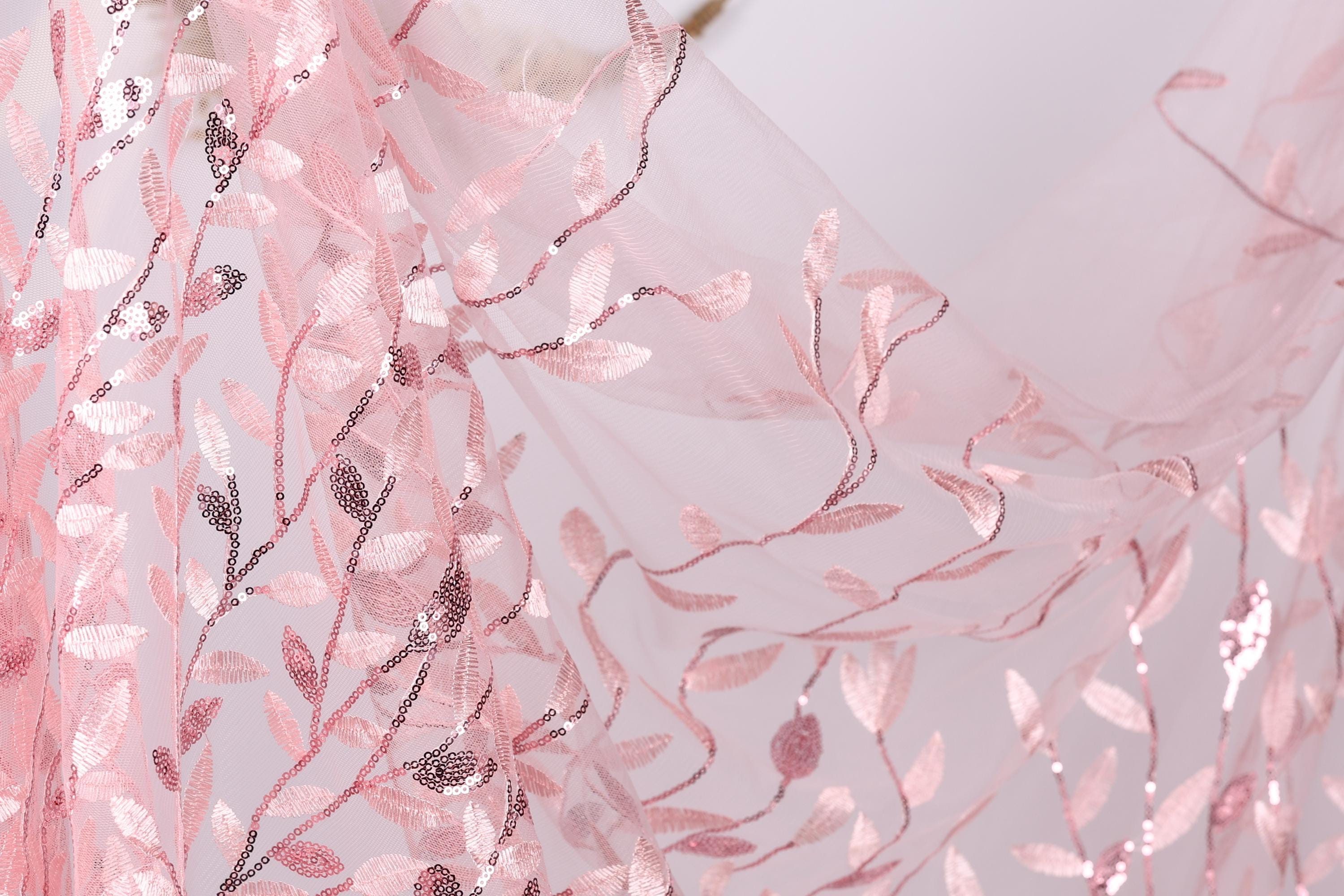 a close-up view of a delicate, pink, and white floral pattern on a fabric, with the leaves and branches intricately woven into the fabric.