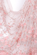 a delicate and intricate piece of fabric adorned with a floral pattern of pink roses and leaves. The fabric appears to be made of sheer material, giving it a soft and delicate appearance. The floral design is spread across the fabric, creating a visually appealing and harmonious pattern.