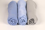Three rolled-up blue and gray towels are arranged in a row on a white background.