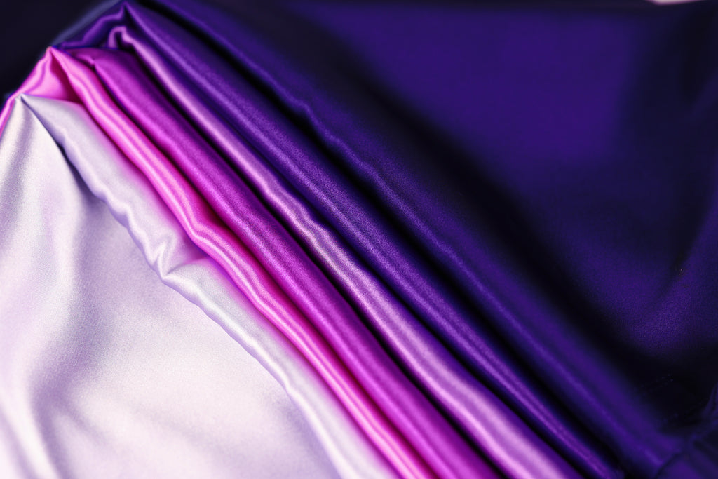 a close-up view of a fabric with a gradient of purple and pink colors, creating a visually striking and vibrant pattern.