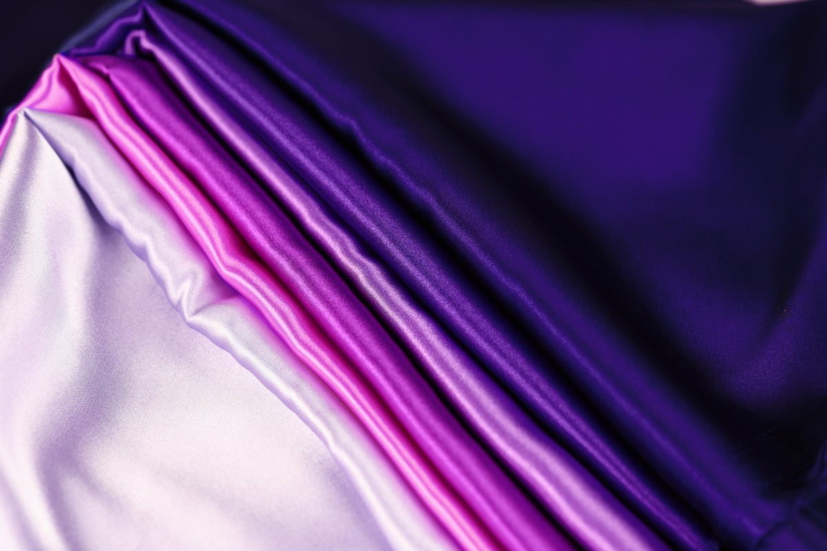 a close-up view of a fabric with a gradient of purple and pink colors, creating a visually striking and vibrant pattern.