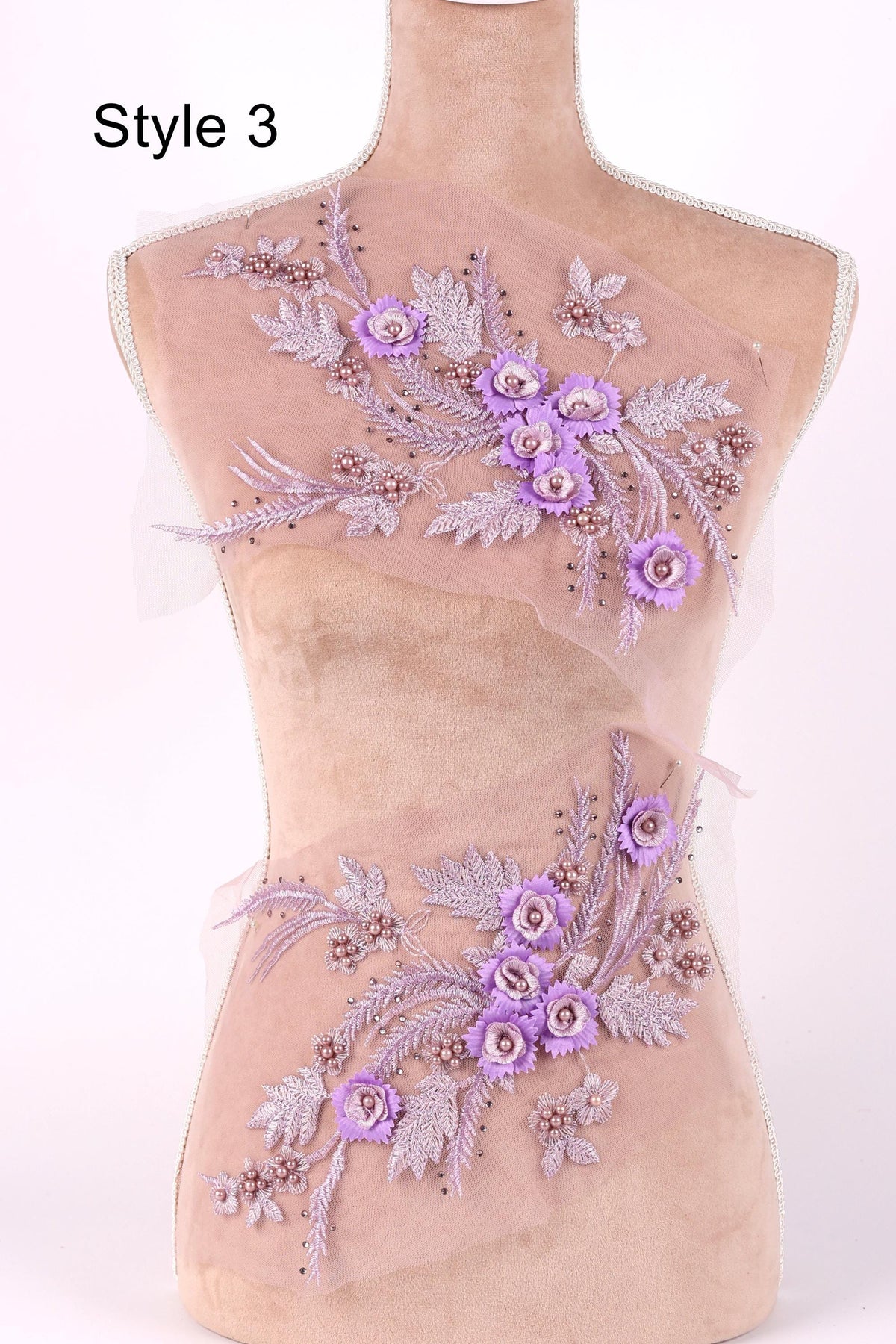 A mannequin with a floral design on its torso, featuring purple flowers and leaves.
