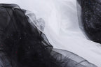 The image is a close-up of a black and white fabric with a textured appearance, featuring a mix of black and white threads or fibers.