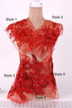 A mannequin wearing a red dress with intricate floral embroidery and beading details.