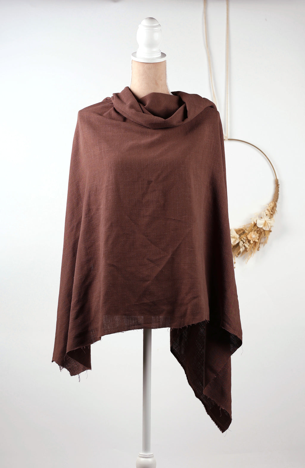 A brown shawl draped over a mannequin torso, displayed on a white mannequin stand against a white background.