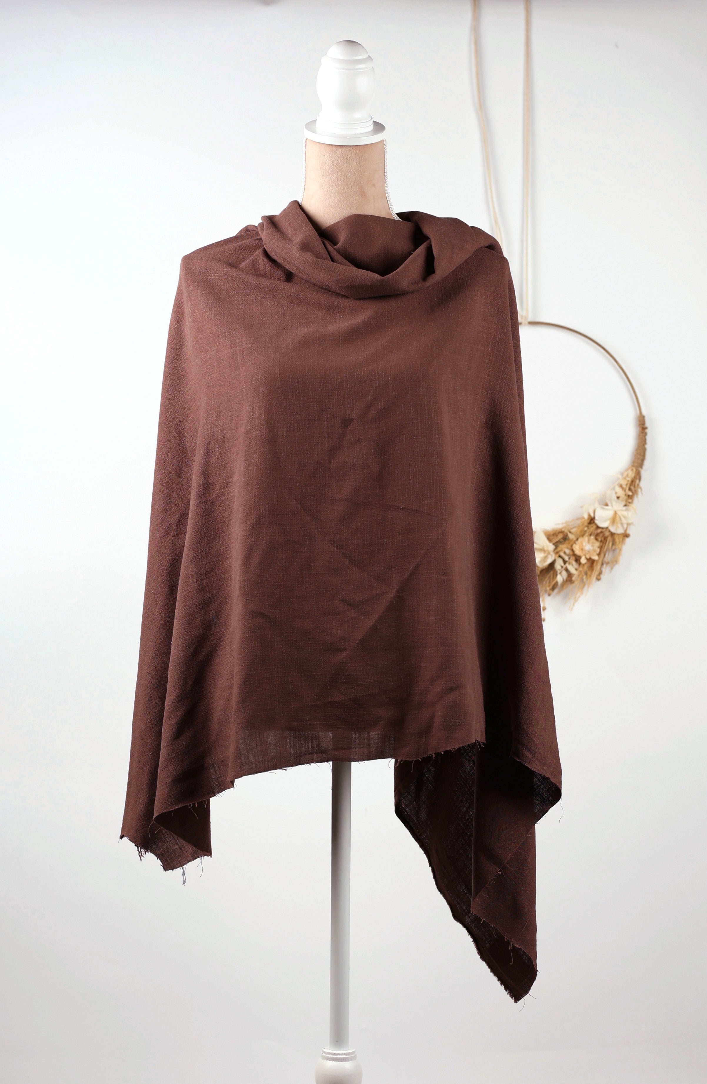 A brown shawl draped over a mannequin torso, displayed on a white mannequin stand against a white background.