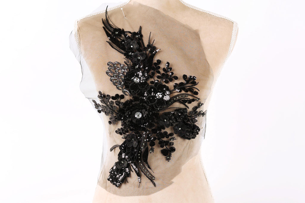 a mannequin with a decorative black floral embellishment on its back.