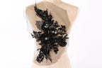 a mannequin with a decorative black floral embellishment on its back.