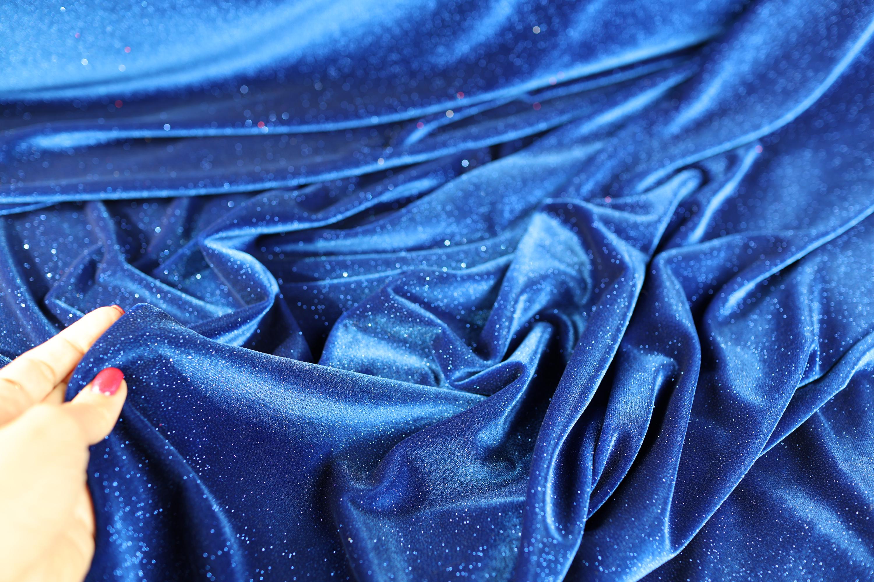 a person's hand on a blue cloth