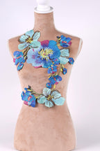 A mannequin wearing a dress with a floral embroidered design on the bust area.