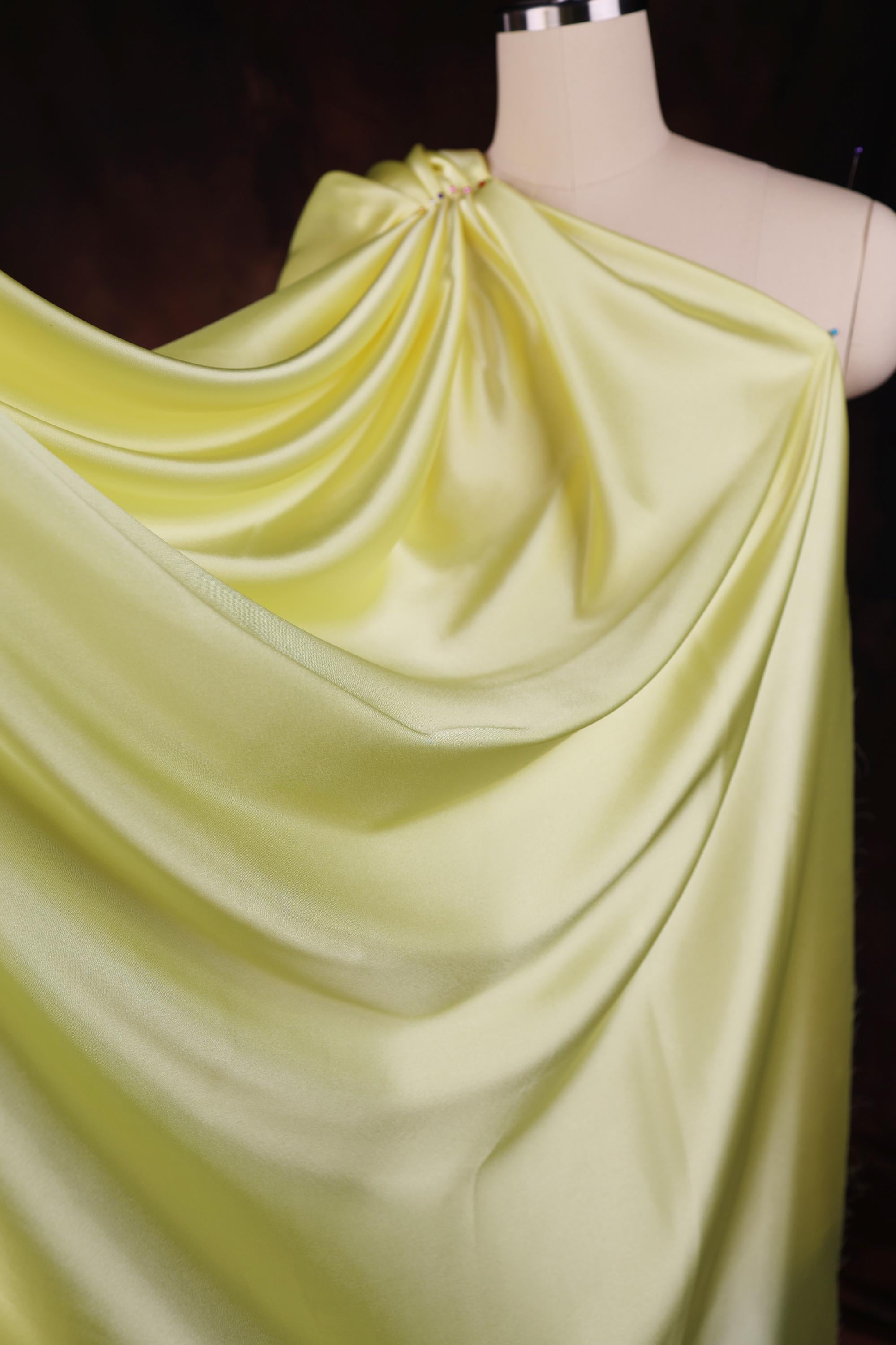 a dress on a mannequin with a yellow draped over it