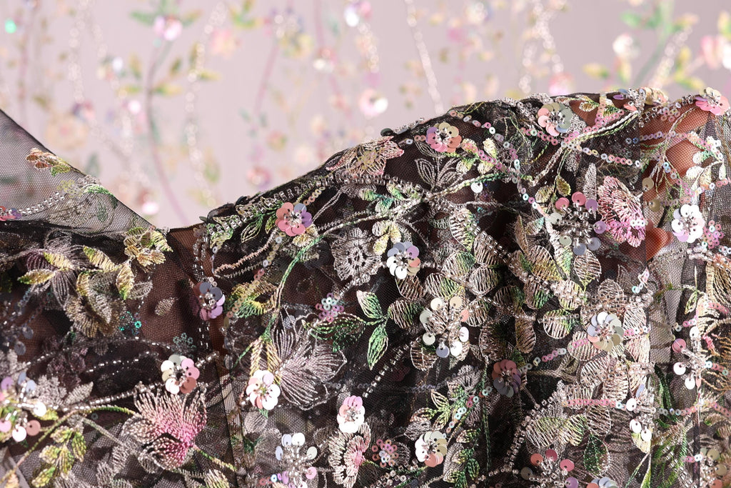 a close-up view of a fabric with a floral pattern, featuring a variety of colorful flowers and leaves.