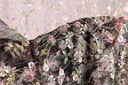 a close-up view of a fabric with a floral pattern, featuring a variety of colorful flowers and leaves.