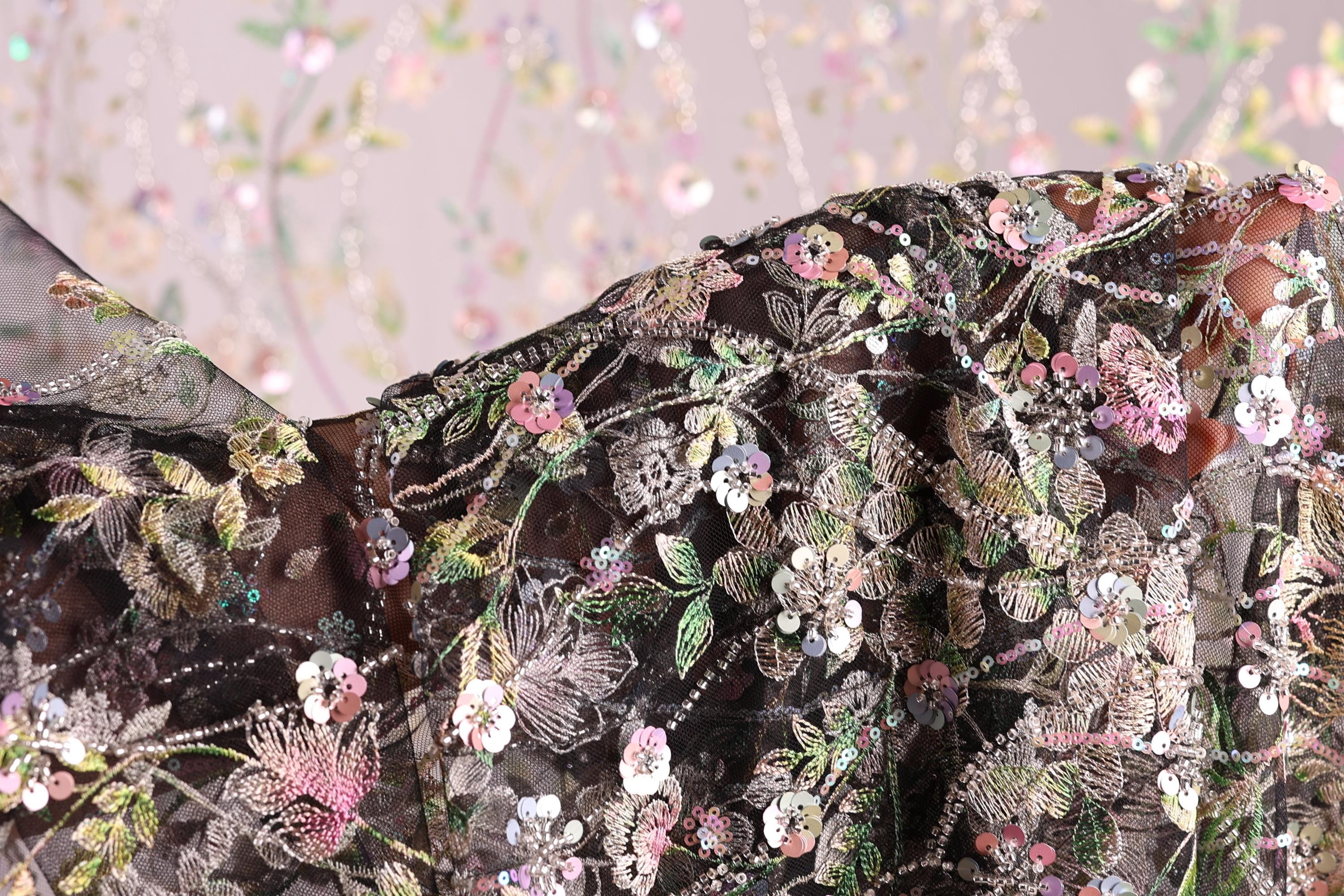 a close-up view of a fabric with a floral pattern, featuring a variety of colorful flowers and leaves.