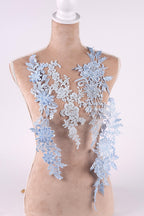 A mannequin wearing a dress with delicate blue lace appliques on the bust area.