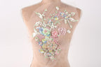 A mannequin with a sheer, floral-patterned fabric draped over its back.