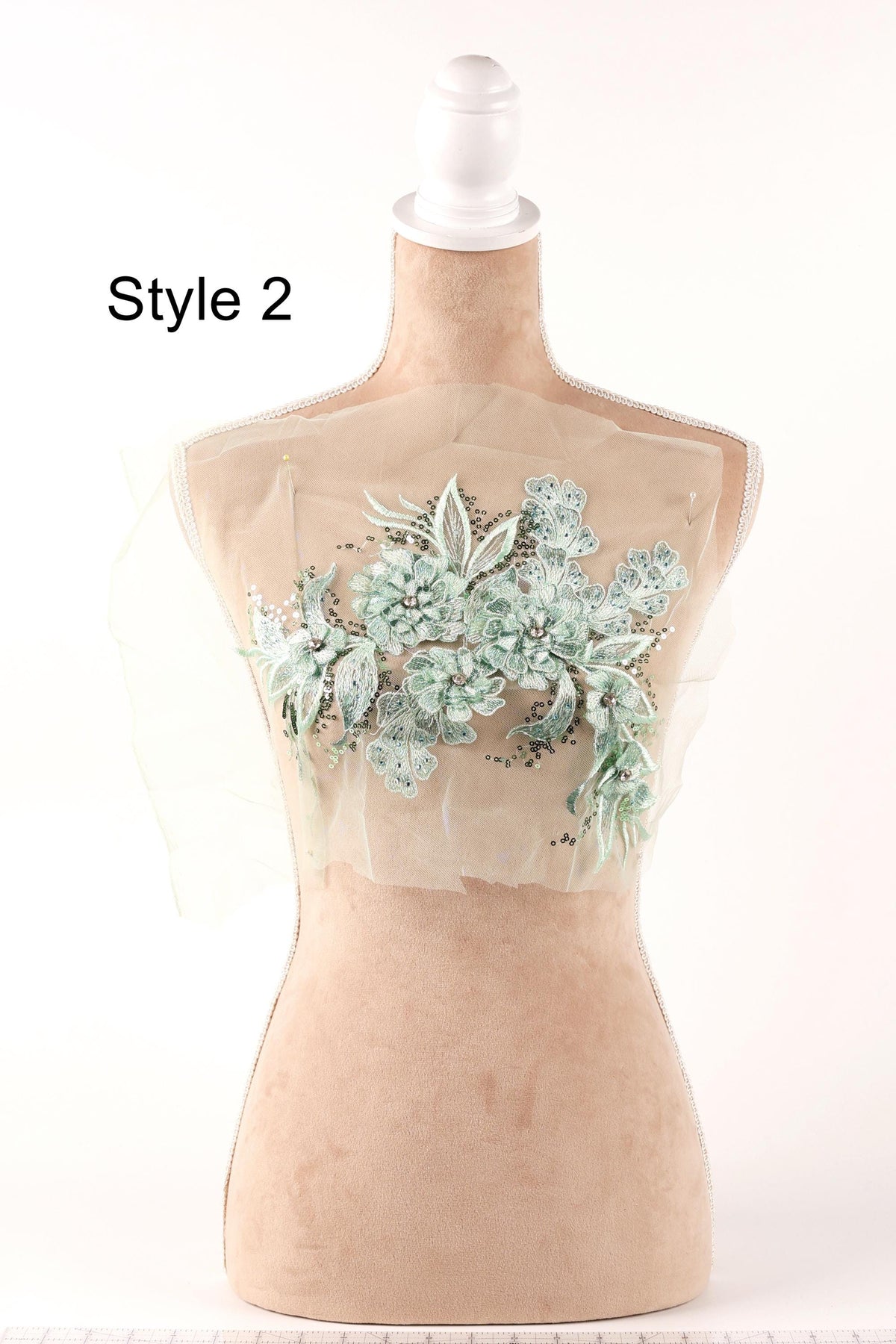 A mannequin with a floral embroidered design on its bust, displayed on a white background.