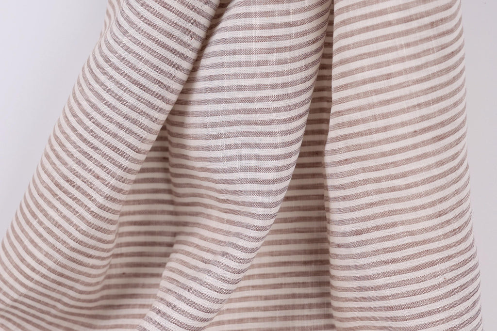 A close-up view of a fabric with horizontal brown and white stripes, creating a textured and patterned appearance.