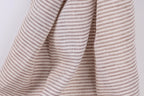 A close-up view of a fabric with horizontal brown and white stripes, creating a textured and patterned appearance.