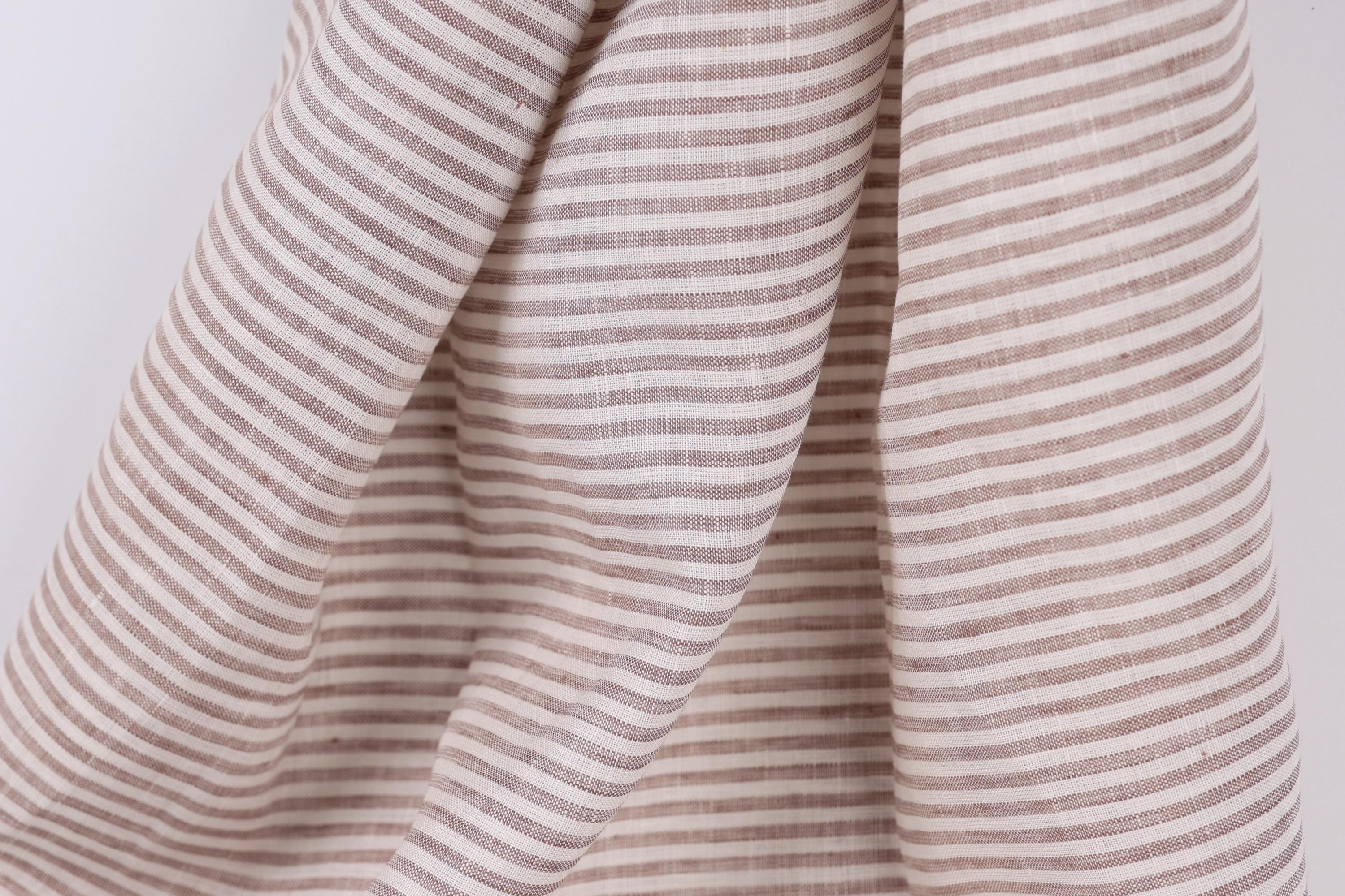 A close-up view of a fabric with horizontal brown and white stripes, creating a textured and patterned appearance.