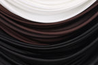 a close-up view of a fabric with a gradient of colors, transitioning from white to brown and black.