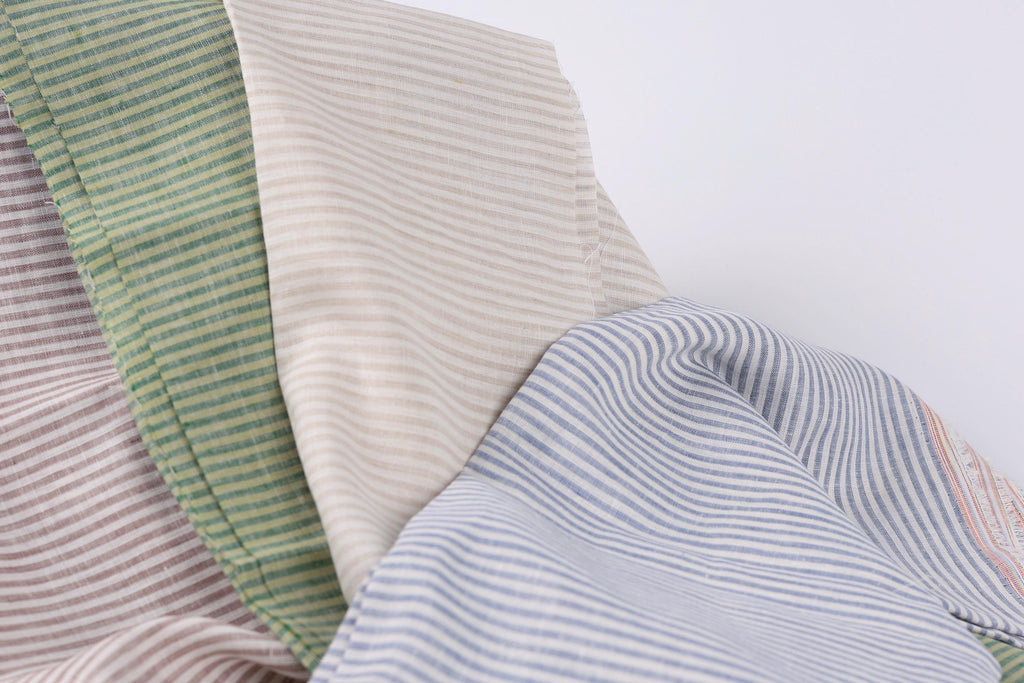 a close-up view of a fabric with horizontal stripes in various colors, including green, beige, and blue.