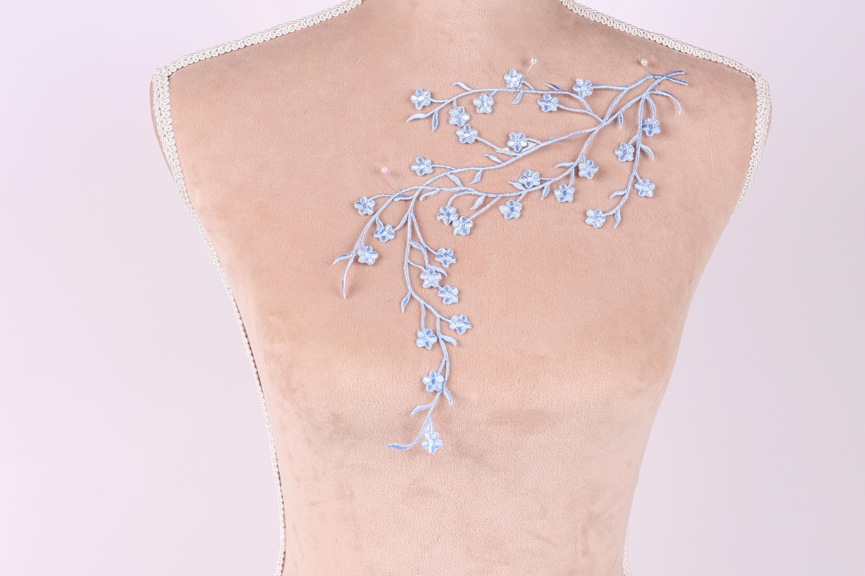 a mannequin with a delicate floral embroidery on its back.