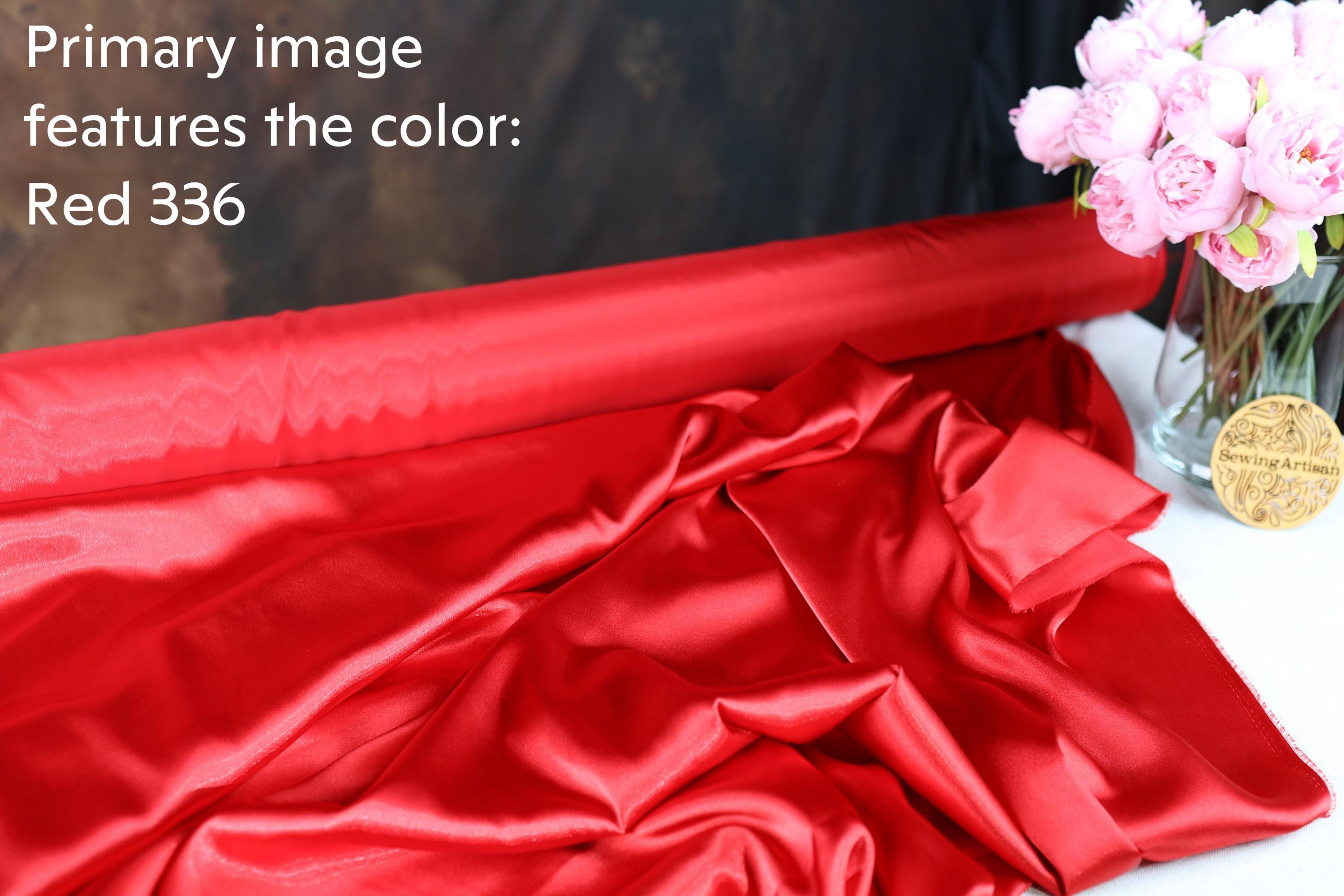 a red fabric roll and a vase of pink flowers on a table.
