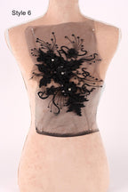 A mannequin with a decorative black lace piece on its back.